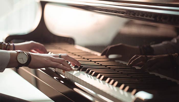 A imagem representa uma pessoa tocando piano. O propósito dela é mostrar que o canceriano com ascendente Sagitário usa a sua sensibilidade para evoluir como ser humano.